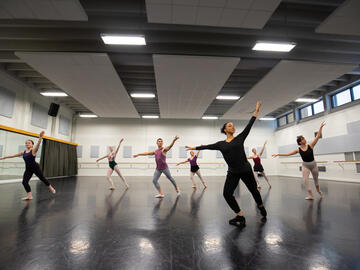 A wide shot of a dance studio filled with dancers