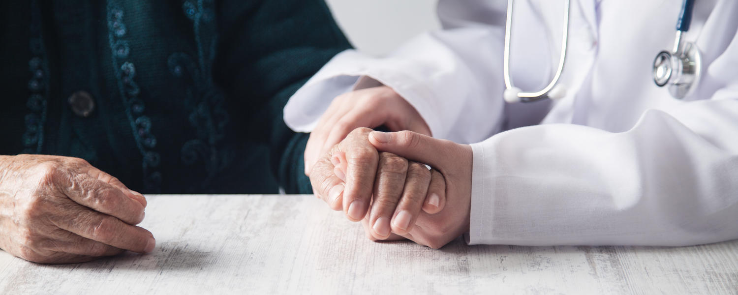 Close up of doctor holding patient's hand