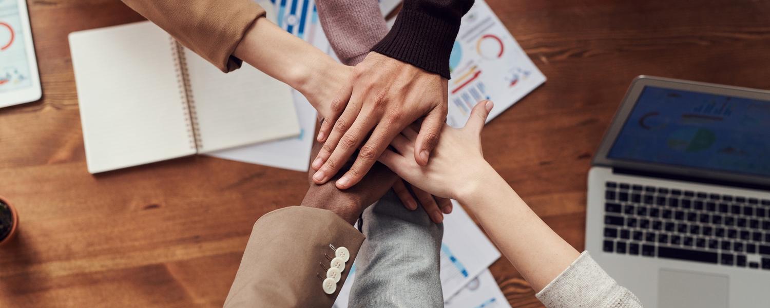 Hands gathered together on a table