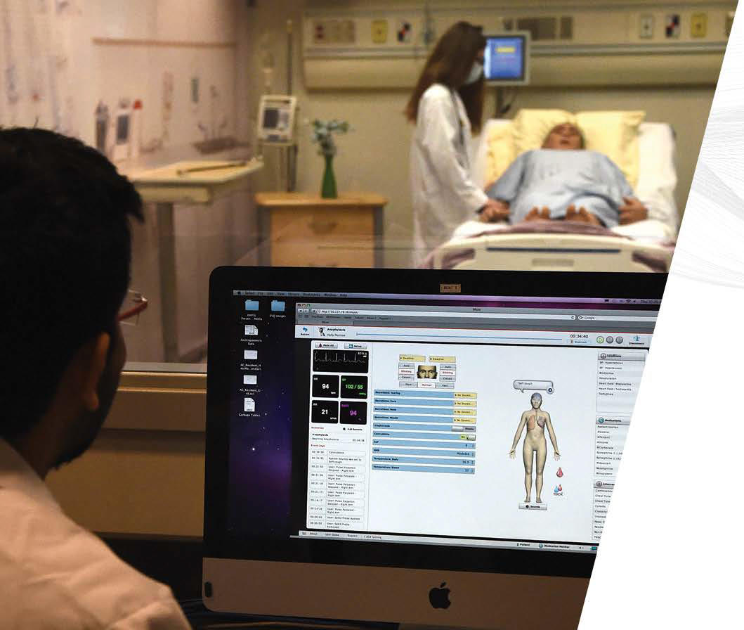 Researcher at a computer simulating hospital conditions