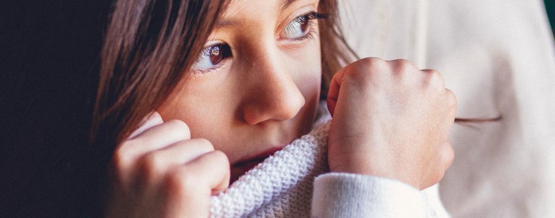 child wearing sweater covering face