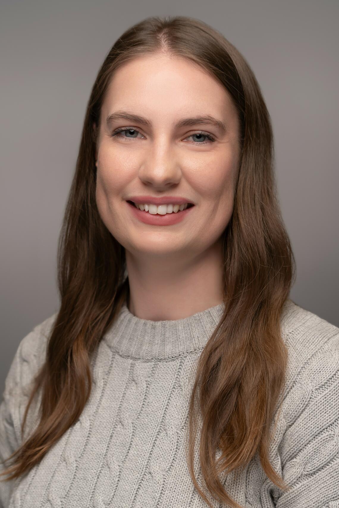 Headshot of Lindsay Morrison, sitting on an angle smiling at the camera
