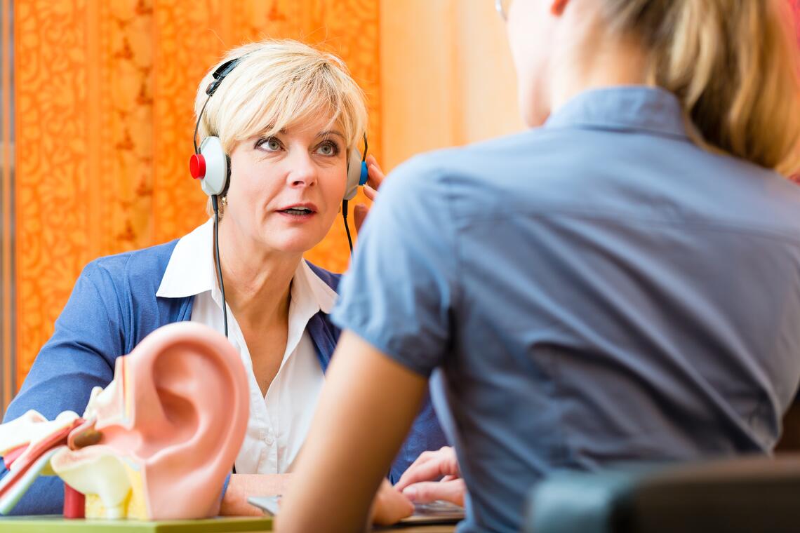 Older woman wearing headphones for hearing test