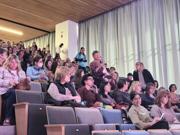 audience at an event, woman in audience standing to ask a question
